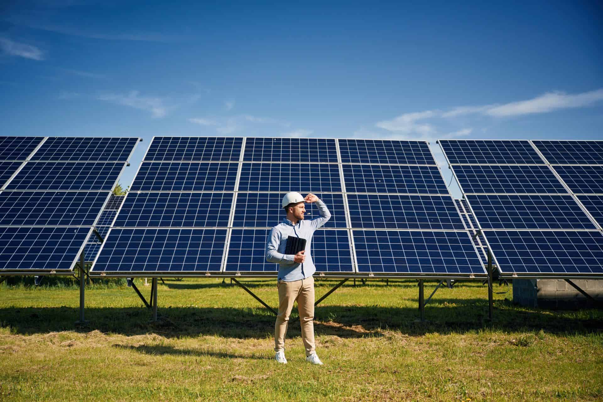 Paneles solares en una granja agrovoltaica, con un investigador inspeccionando la instalación.