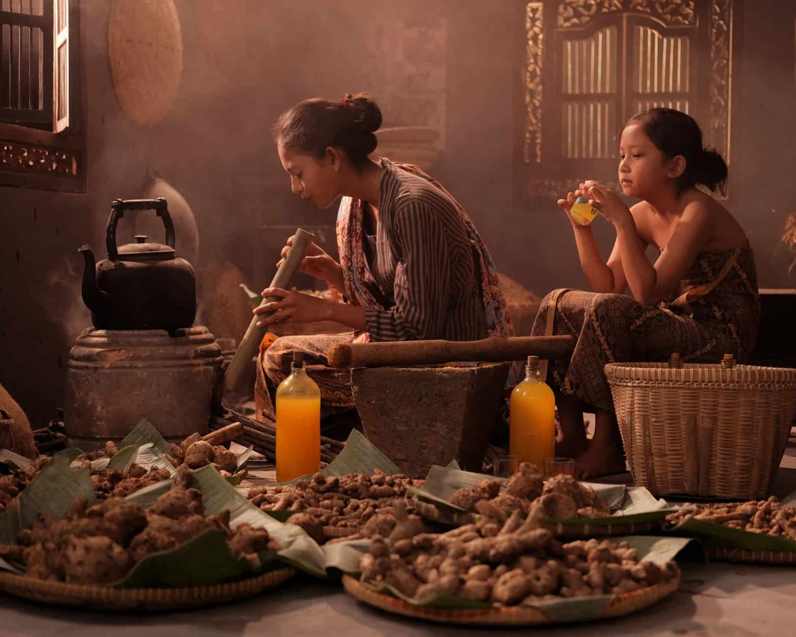Mother and daughter preparing traditional Jamu in an Indonesian home setting.