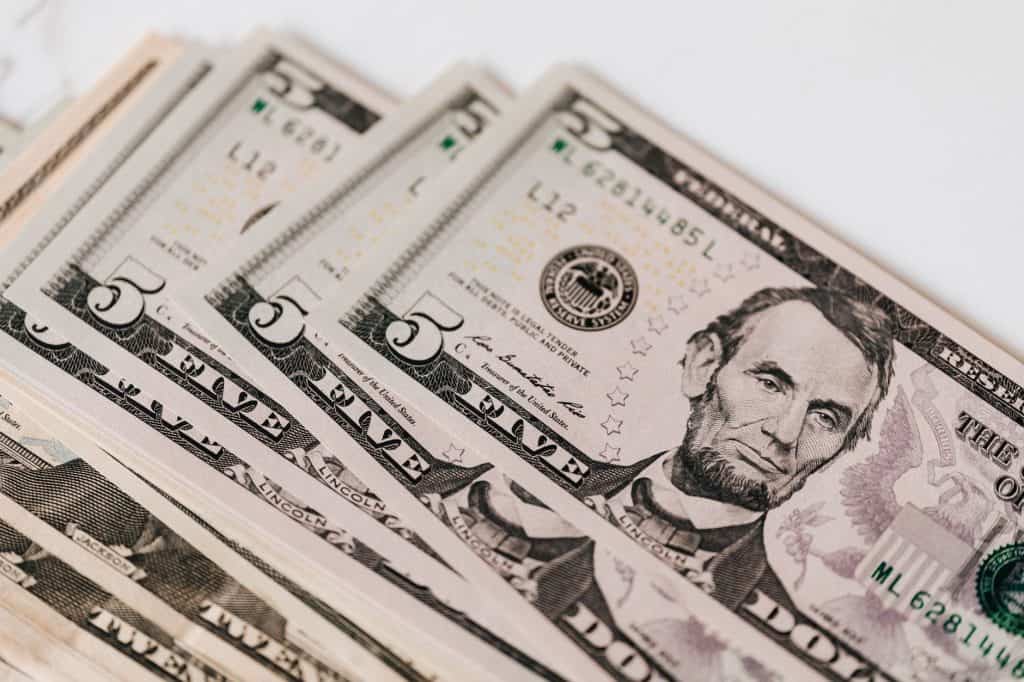 Top view of stack of US dollar banknotes placed together on white background