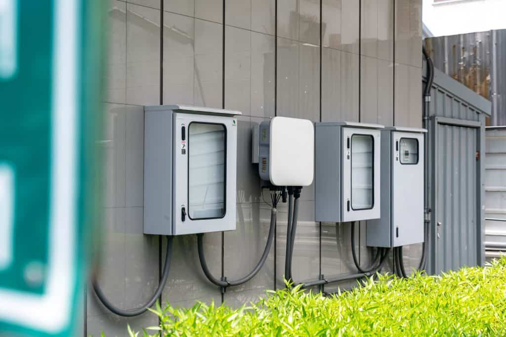 Close-up of outdoor electrical utility boxes with cabling on a building exterior.
